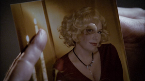 La photo d'Ellen Tigh brûlée au cigare par Saul Tigh visible dans Battlestar Galactica, 1re partie, personnifiée par Jennifer Birchfield-Eick, la femme de David Eick.