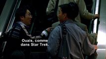 Hiro et Ando discutent de la manipulation de l'espace-temps alors qu'ils montent un escalator dans la station de métro.